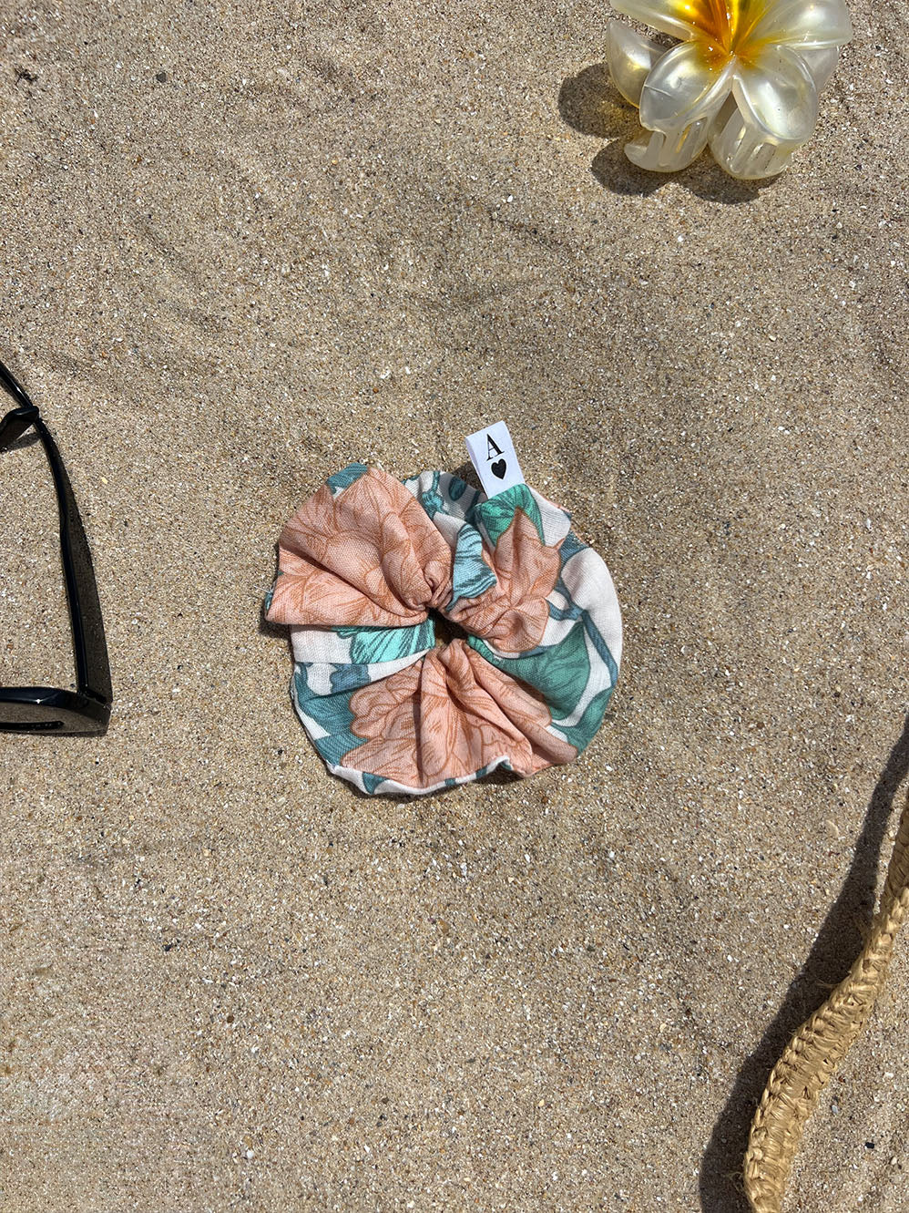 chouchou en gaze peonies posé sur le sable