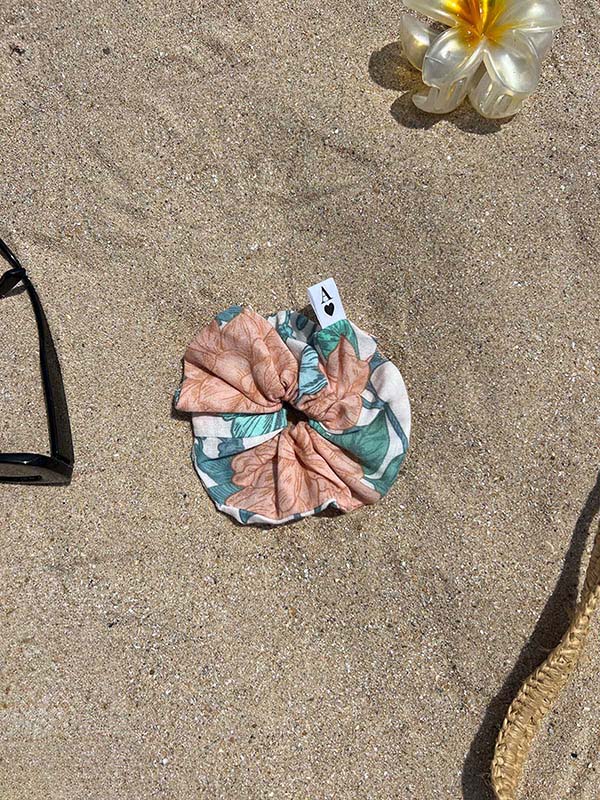 chouchou en gaze peonies posé sur le sable