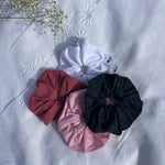 lot de 4 chouchou en popeline et jersey pointelle posé sur un drap