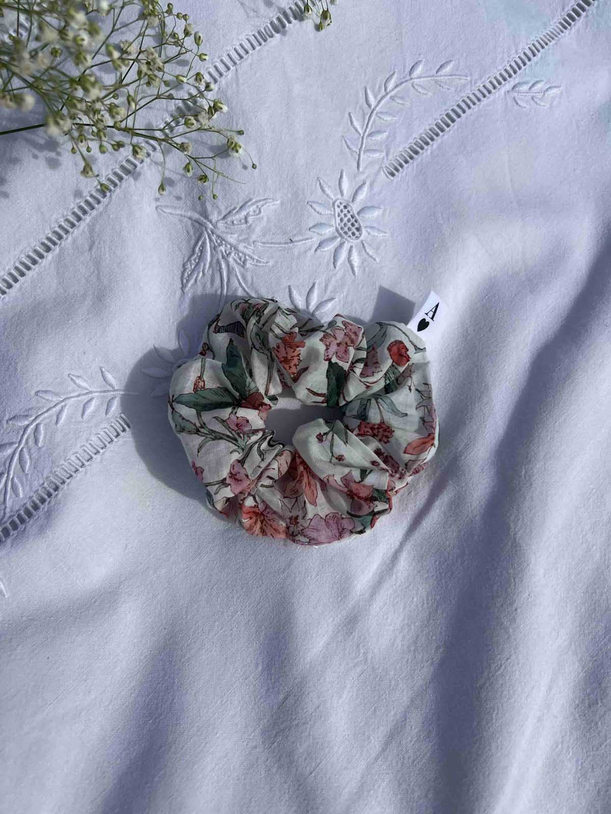 chouchou à fleurs spring posé sur un drap