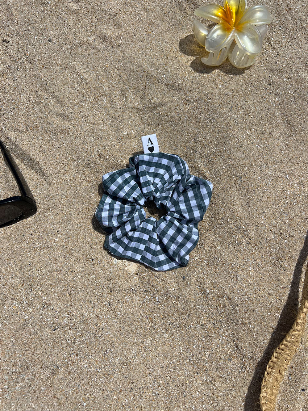 chouchou en popeline vichy vert et blanc posé sur le sable