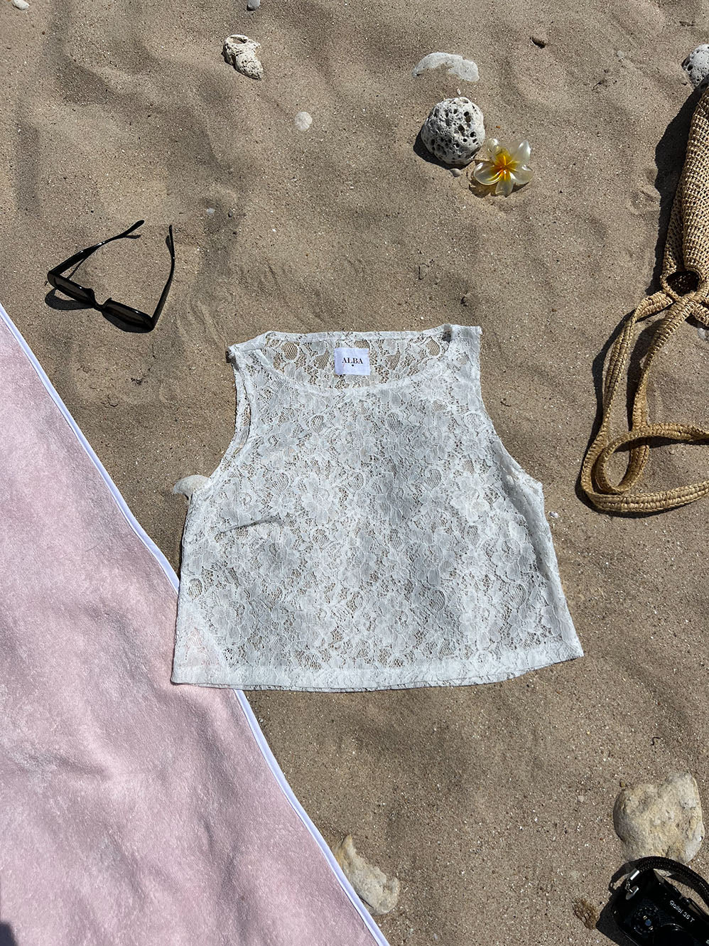 top Douceur en dentelle blanc posé sur le sable