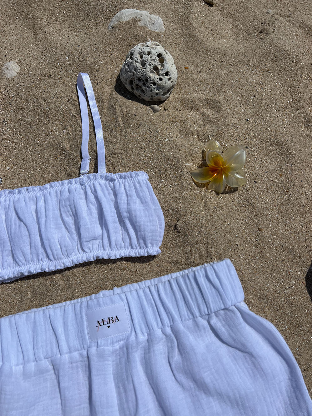 ensemble coton gaze blanc brassière Pauline et short Paul posé sur le sable