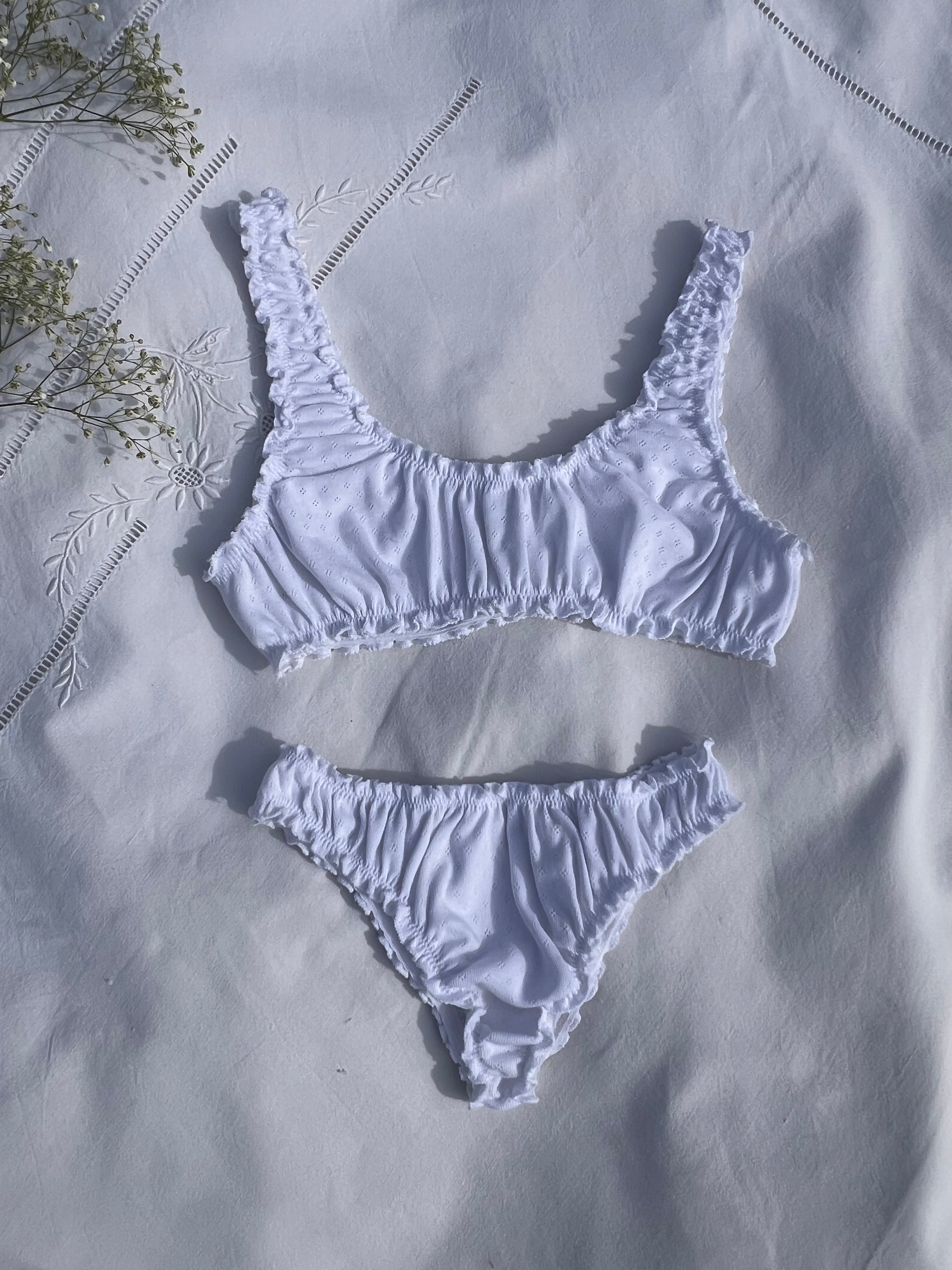 ensemble rosalie brassière et tanga en jersey pointelle blanc posé sur un drap