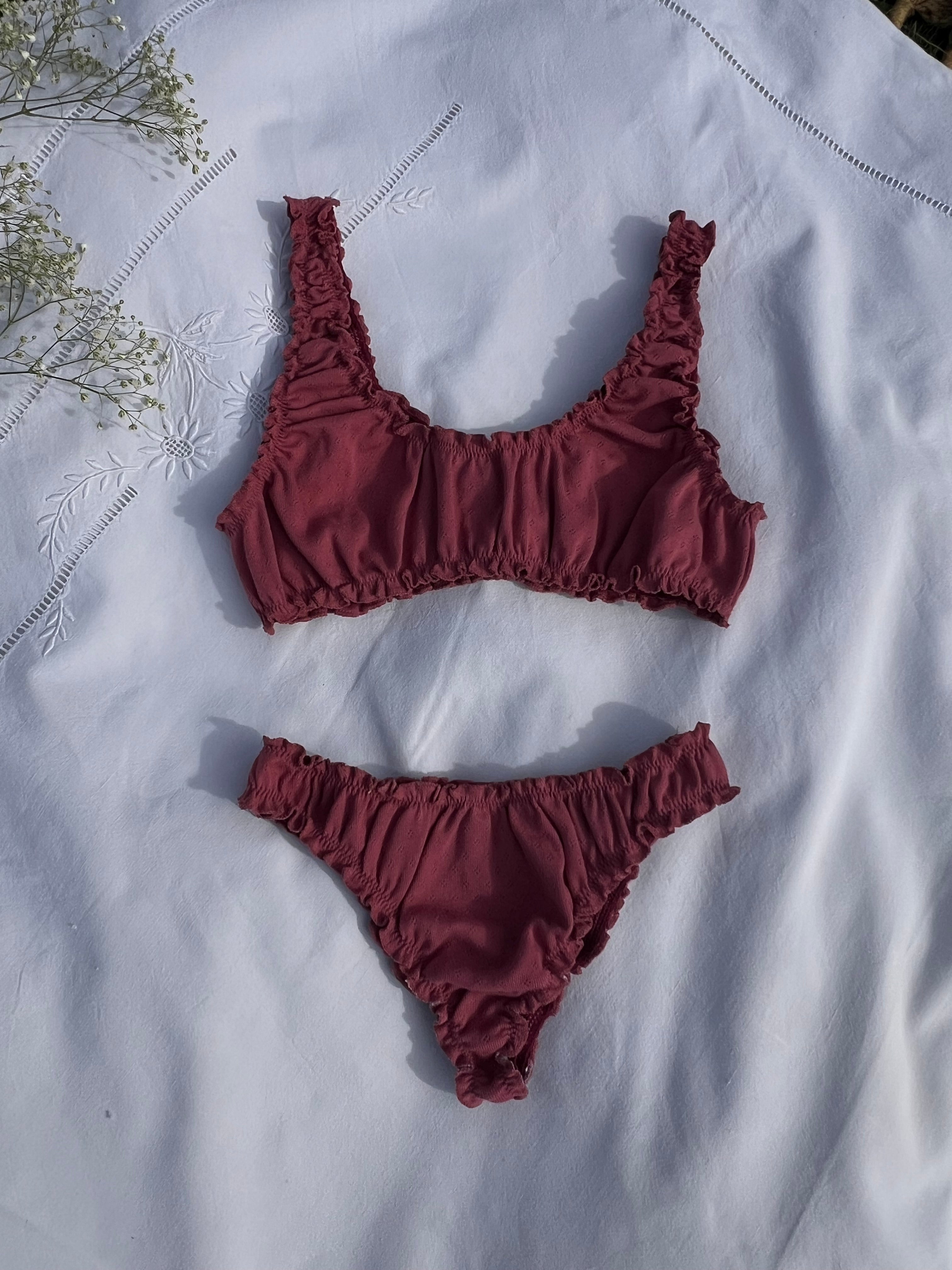 ensemble rosalie brassière et tanga en jersey pointelle framboise posés sur un drap