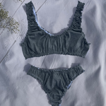 ensemble rosalie brassière et tanga en jersey pointelle gris posé sur un drap