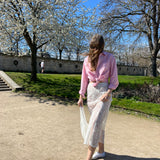 jupe jeanne en dentelle blanche porté en extérieur en mouvement avec sac en dentelle et chemise gaby en popeline rose