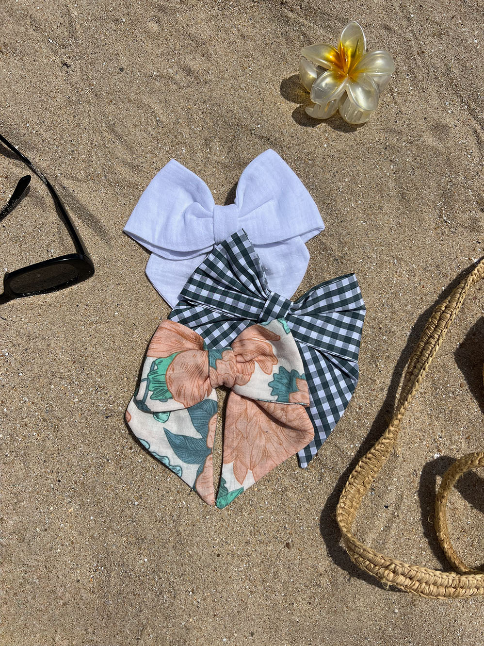 ensemble de trois nœuds à cheveux multicolores posés sur le sable 