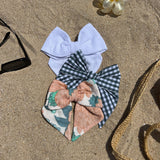 ensemble de trois nœuds à cheveux multicolores posés sur le sable 
