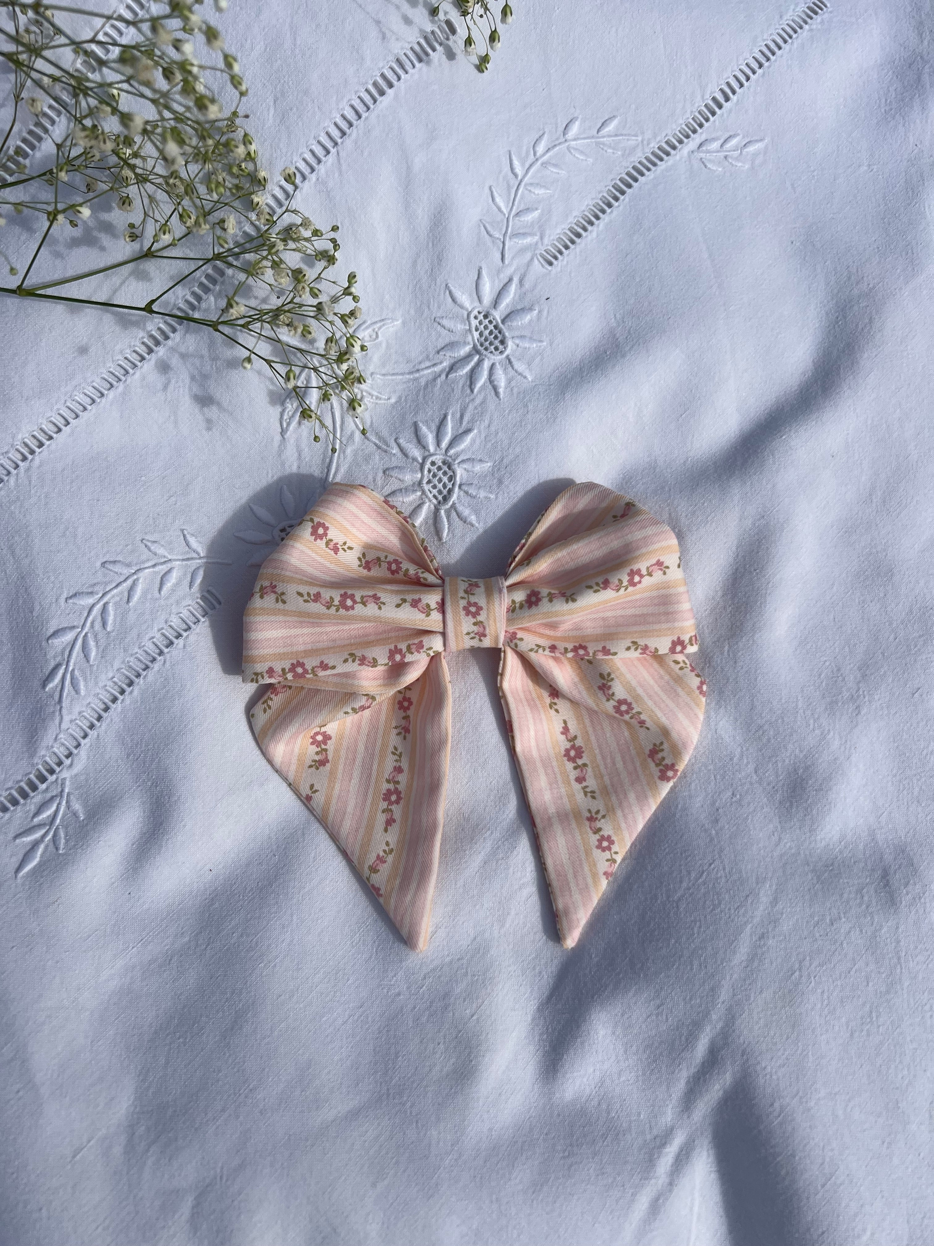  nœud à cheveux en coton rayures à fleurs posé sur drap