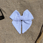 nœud à cheveux en coton gaze blanc posé sur le sable