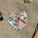 nœud à cheveux en gaze peonies posé sur le sable