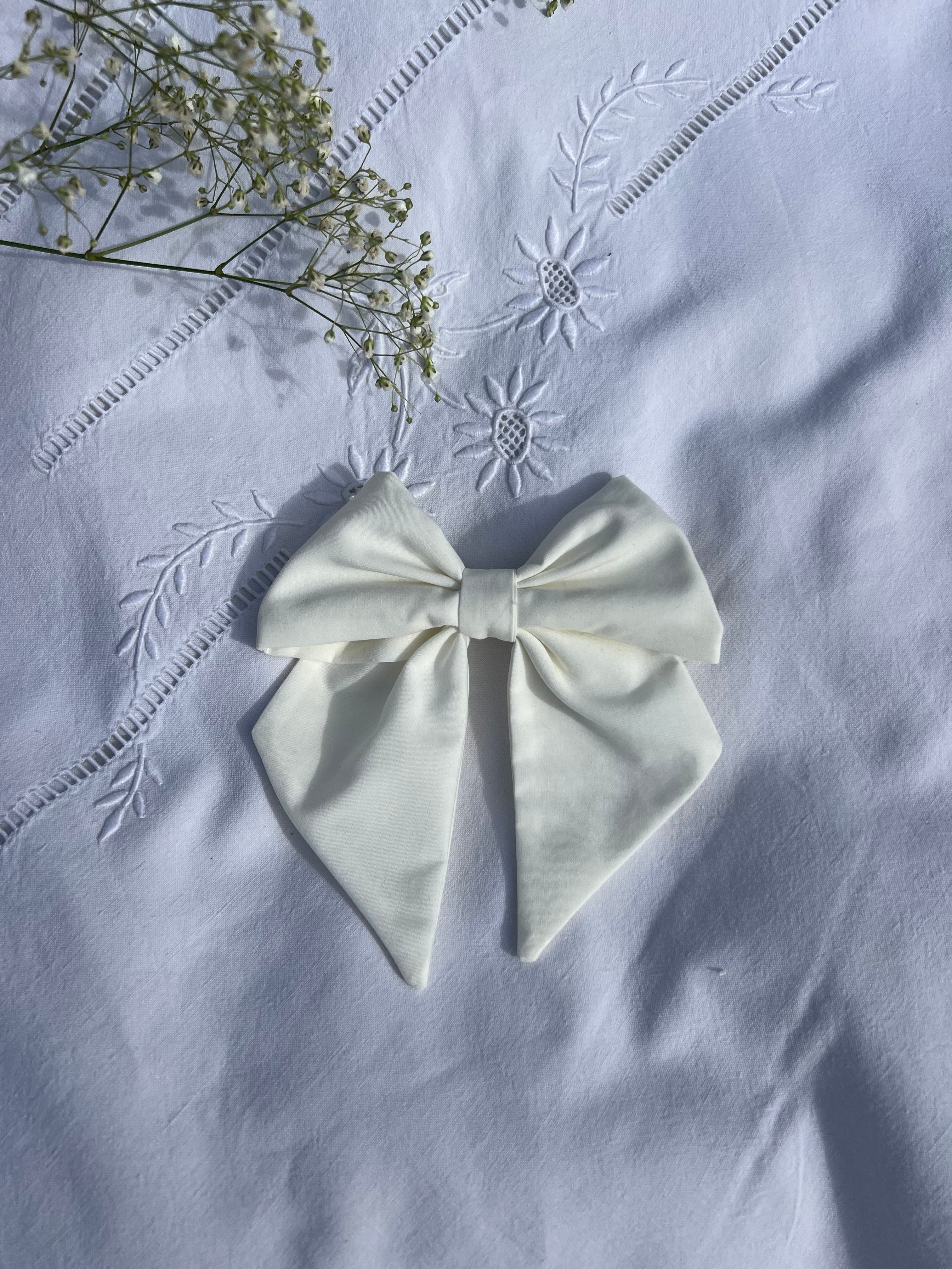 nœud à cheveux en popeline blanc posé sur un drap