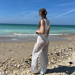 pantalon Léo en dentelle blanc porté avec top Douceur assortis, à la plage
