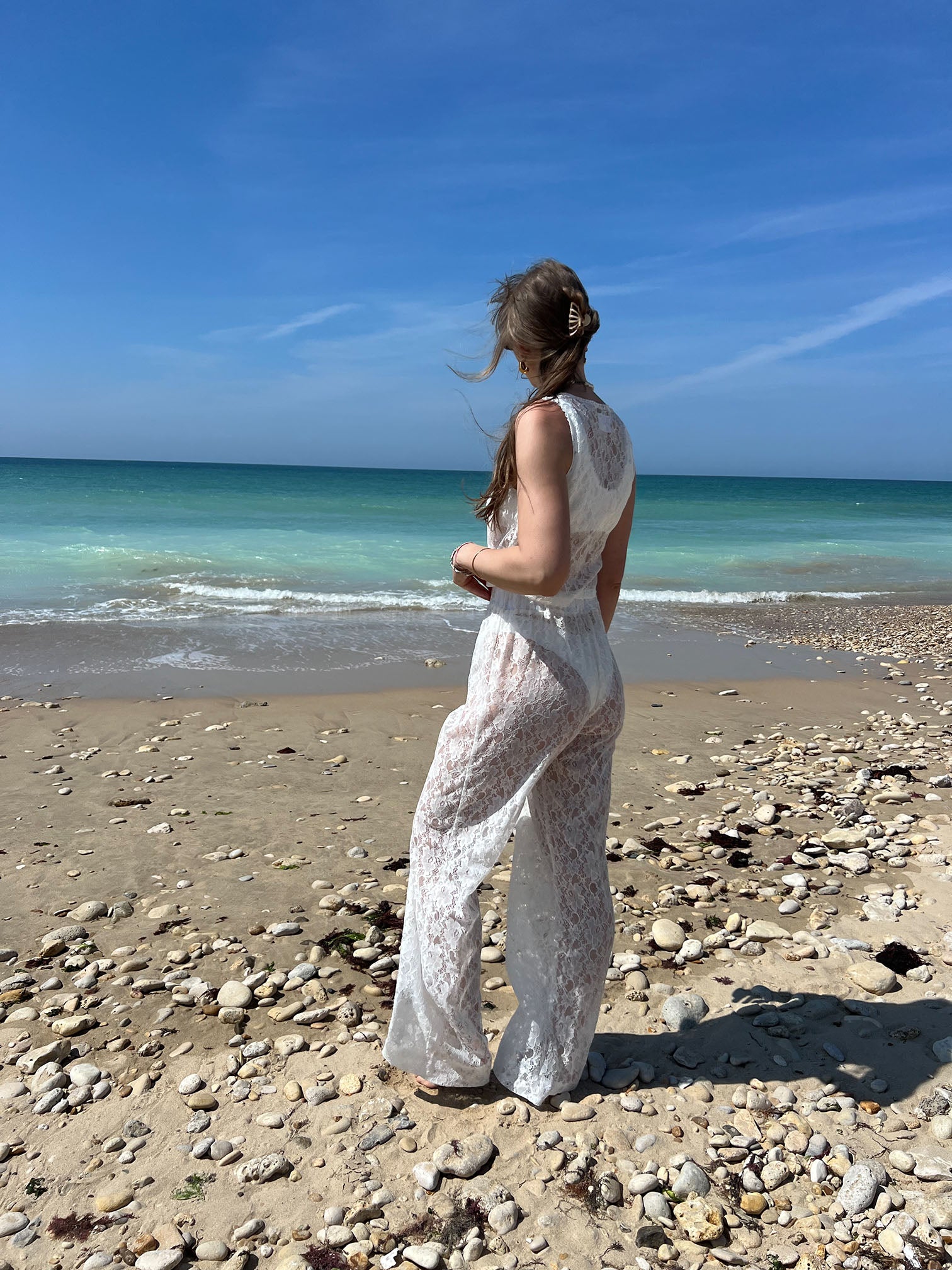 pantalon Léo en dentelle blanc porté avec top Douceur assortis, à la plage