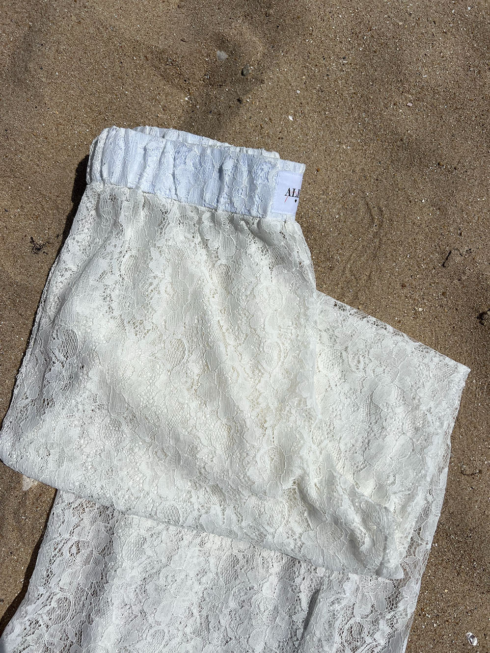 pantalon Léo en dentelle posé sur le sable, zoom détails