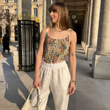 pantalon leo en lin blanc porté en extérieur avec corset et sac
