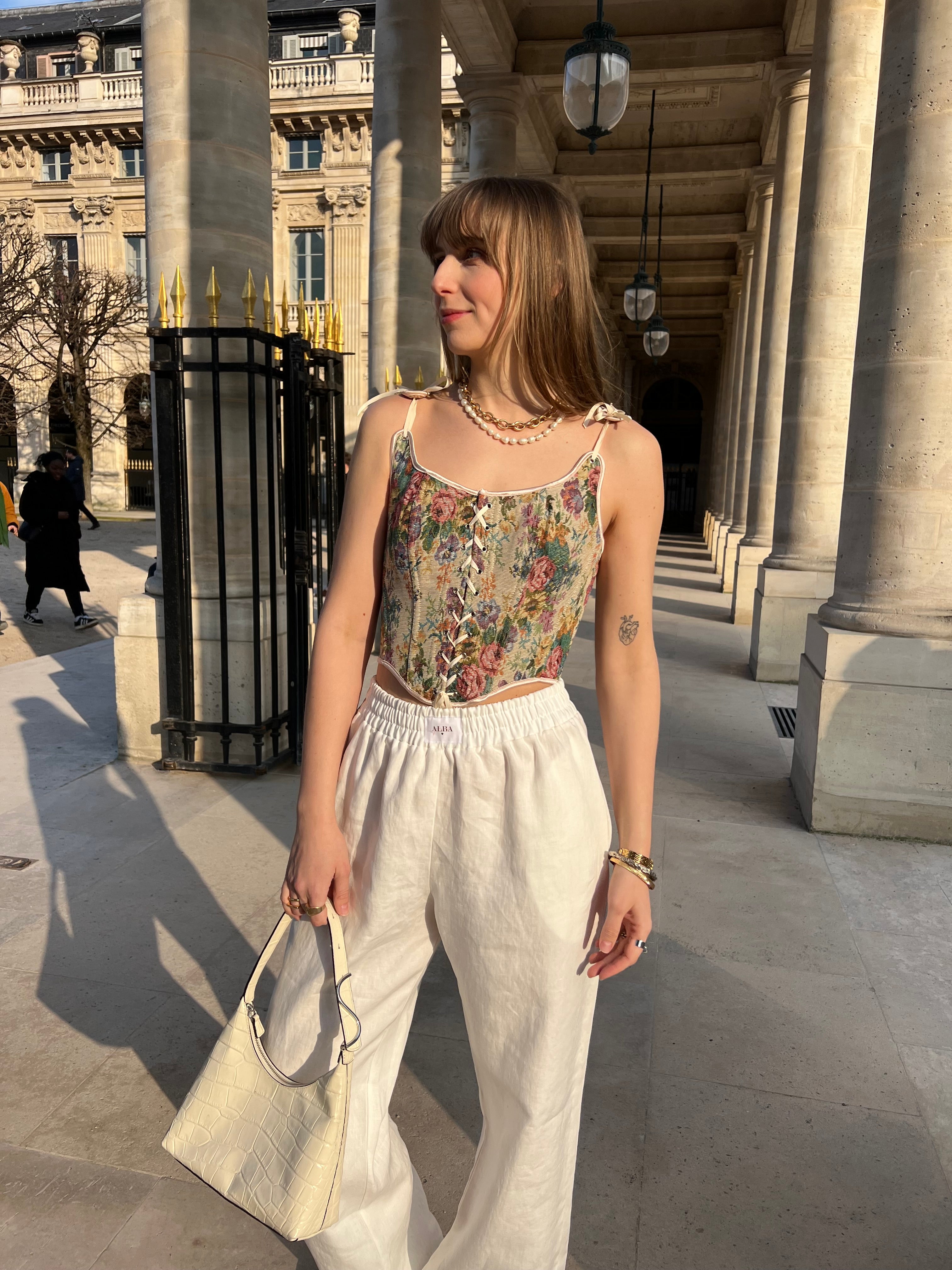 pantalon leo en lin blanc porté en extérieur avec corset et sac