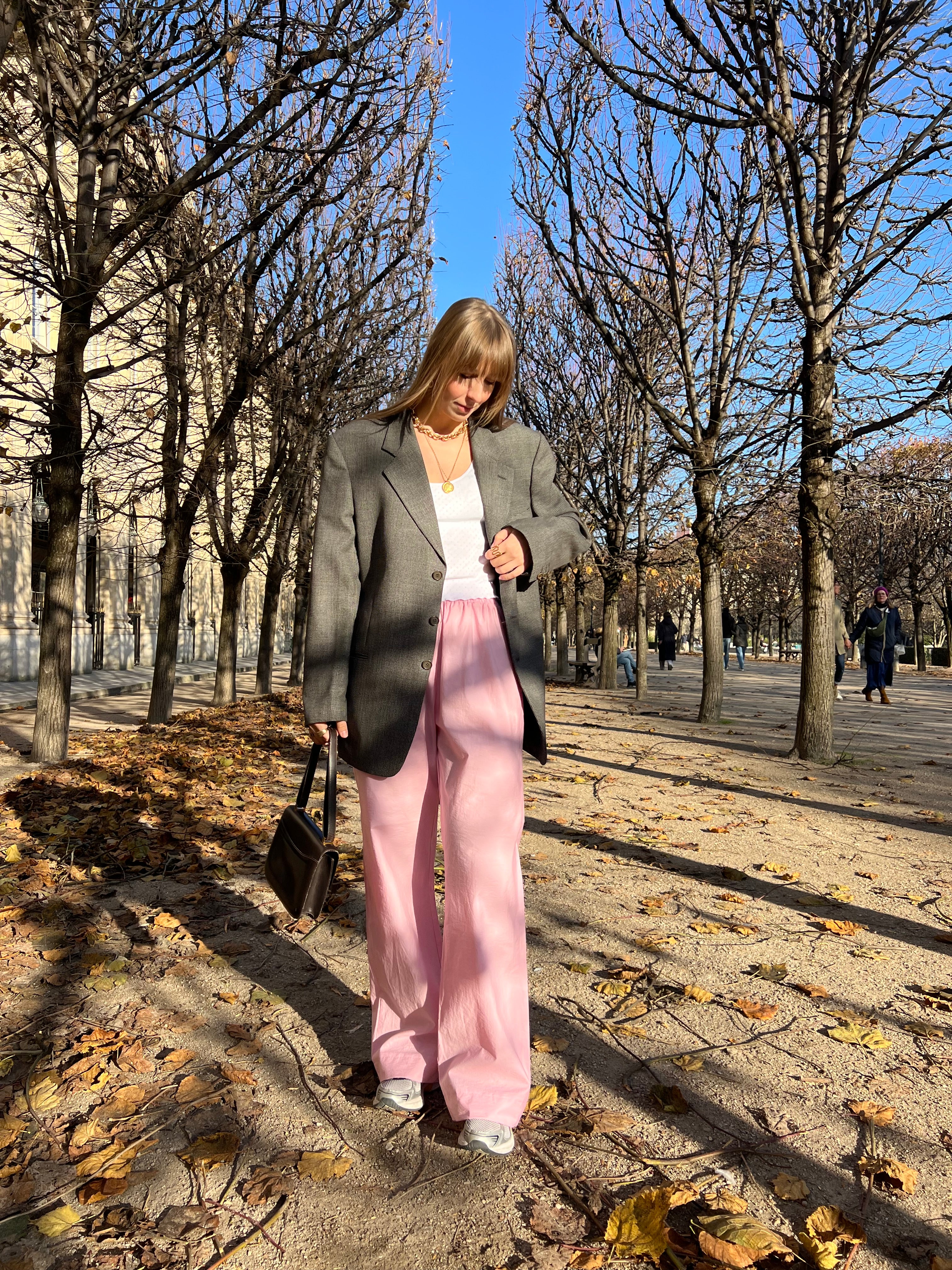 Look pantalon rose, et débardeur blanc en jersey pointelle et veste grise de costume.