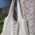 sac mael en dentelle blanche porté à la main avec jupe jeanne en dentelle blanche 
