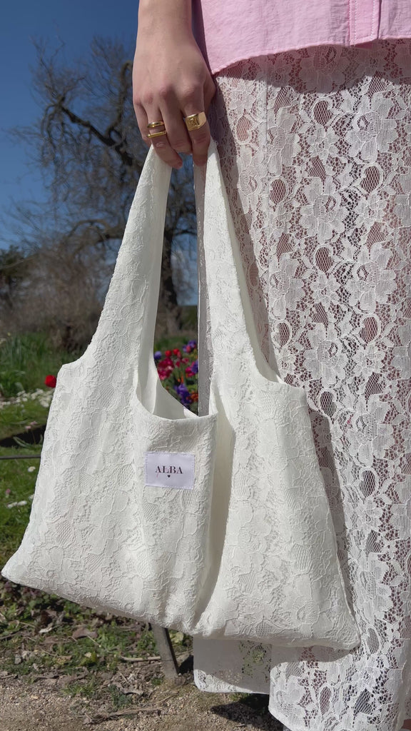 sac mael en dentelle blanche porté à la main avec jupe jeanne en dentelle blanche 