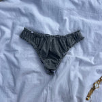 tanga rosalie gris en jersey pointelle posé sur un draps 