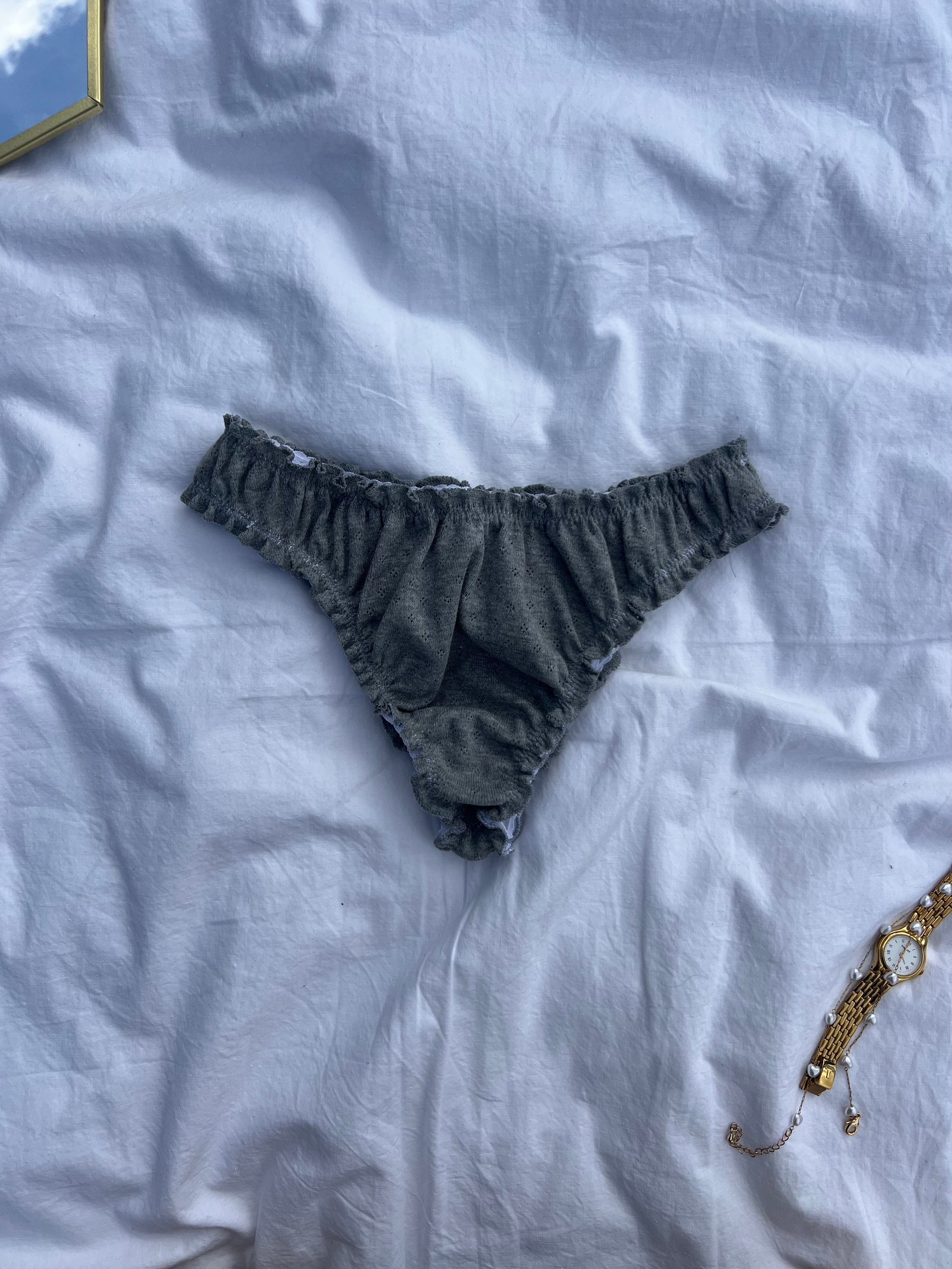 tanga rosalie gris en jersey pointelle posé sur un draps 