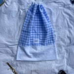sac à chaussures / rangement, broderie anglaise et popeline vichy bleu, fermé et posé sur un drap