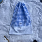 sac à chaussures / rangement, broderie anglaise et popeline vichy bleu, fermé et posé sur un drap