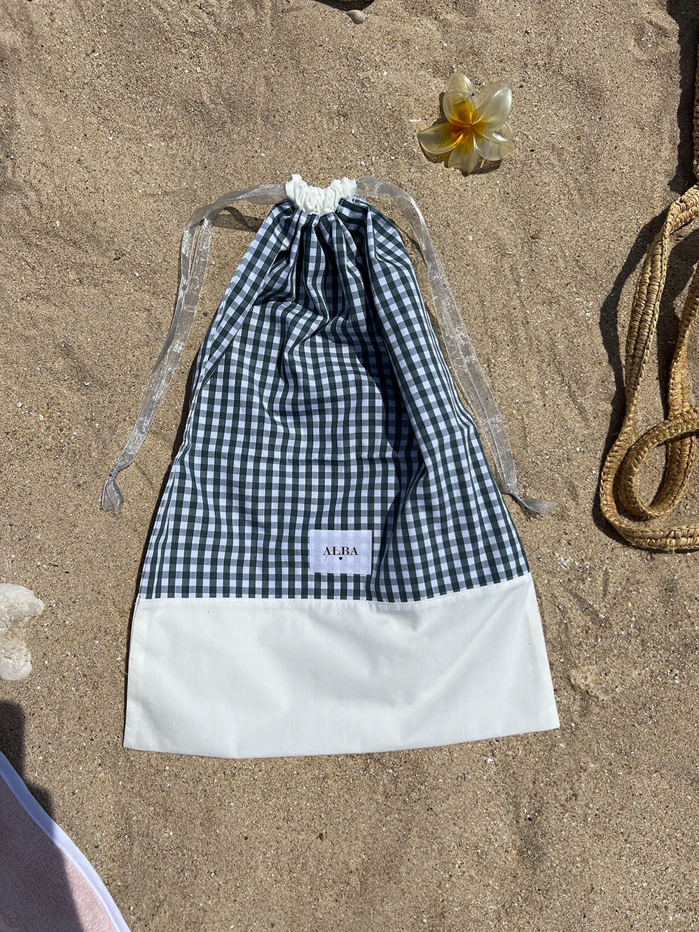 sac à chaussure en popeline vichy vert et blanc, fermé et posé sur le sable