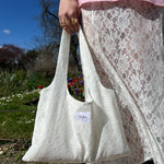 sac mael en dentelle blanche porté à la main en extérieur avec jupe en dentelle jeanne, vue de près