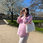 sac mael en dentelle blanche porté à l'épaule en extérieur avec jupe jeanne en dentelle blanche assortis