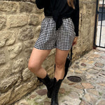 Look tendance ALBA – short Lucas vichy noir porté avec haut noir et sac à main
